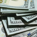 Contact Us ~ Messy stack of hundred dollar bills.